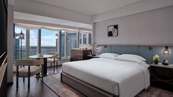 Una habitación de hotel moderna con una cama grande, un escritorio y una silla.