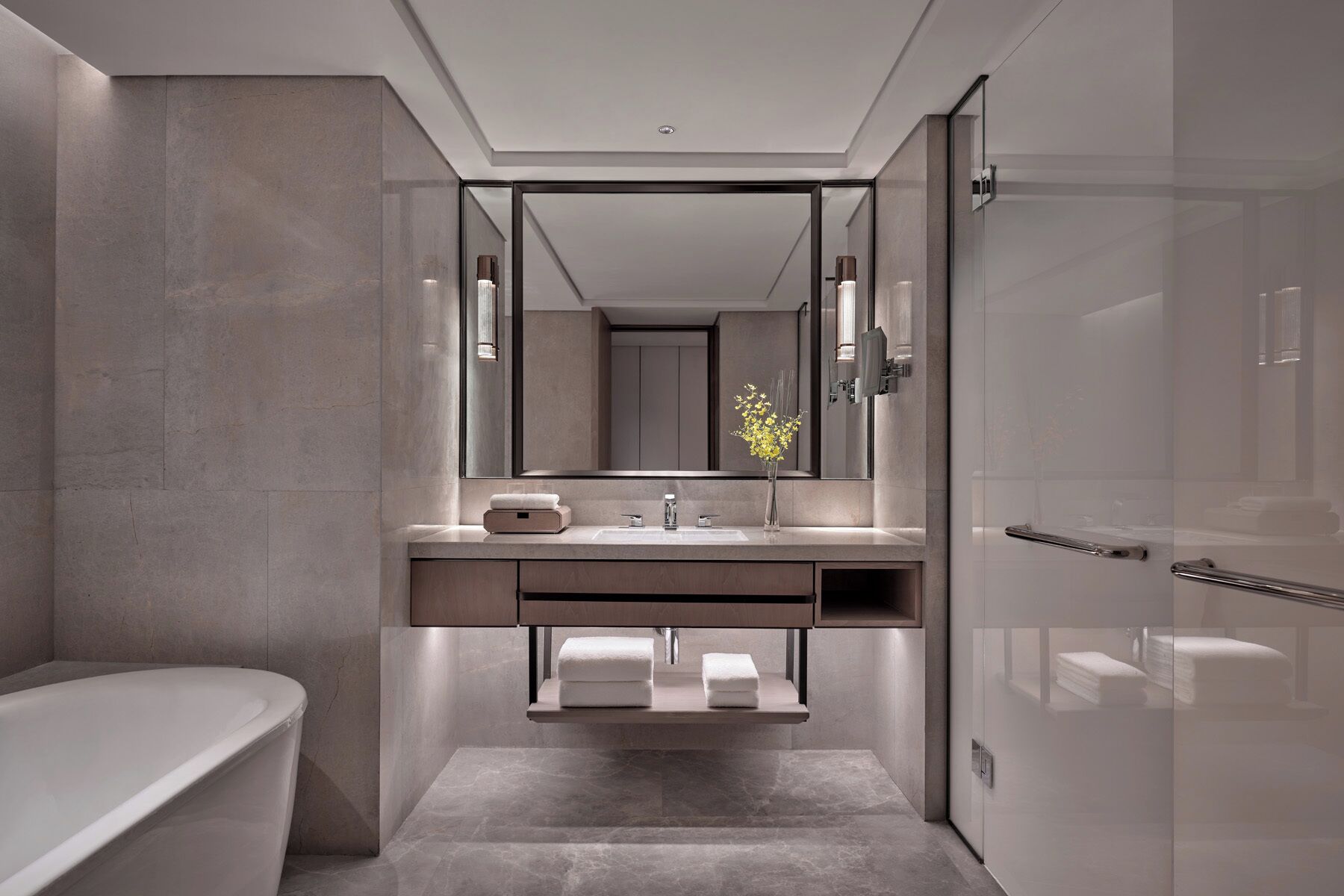 A modern bathroom with a freestanding bathtub, a large mirror, and a minimalist sink area.