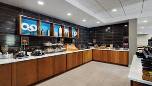 Une cuisine d’hôtel moderne, équipée d’un buffet proposant une grande variété de plats et d’appareils de cuisine.