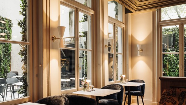 Un interior de restaurante con ventanas amplias, mesas y sillas.