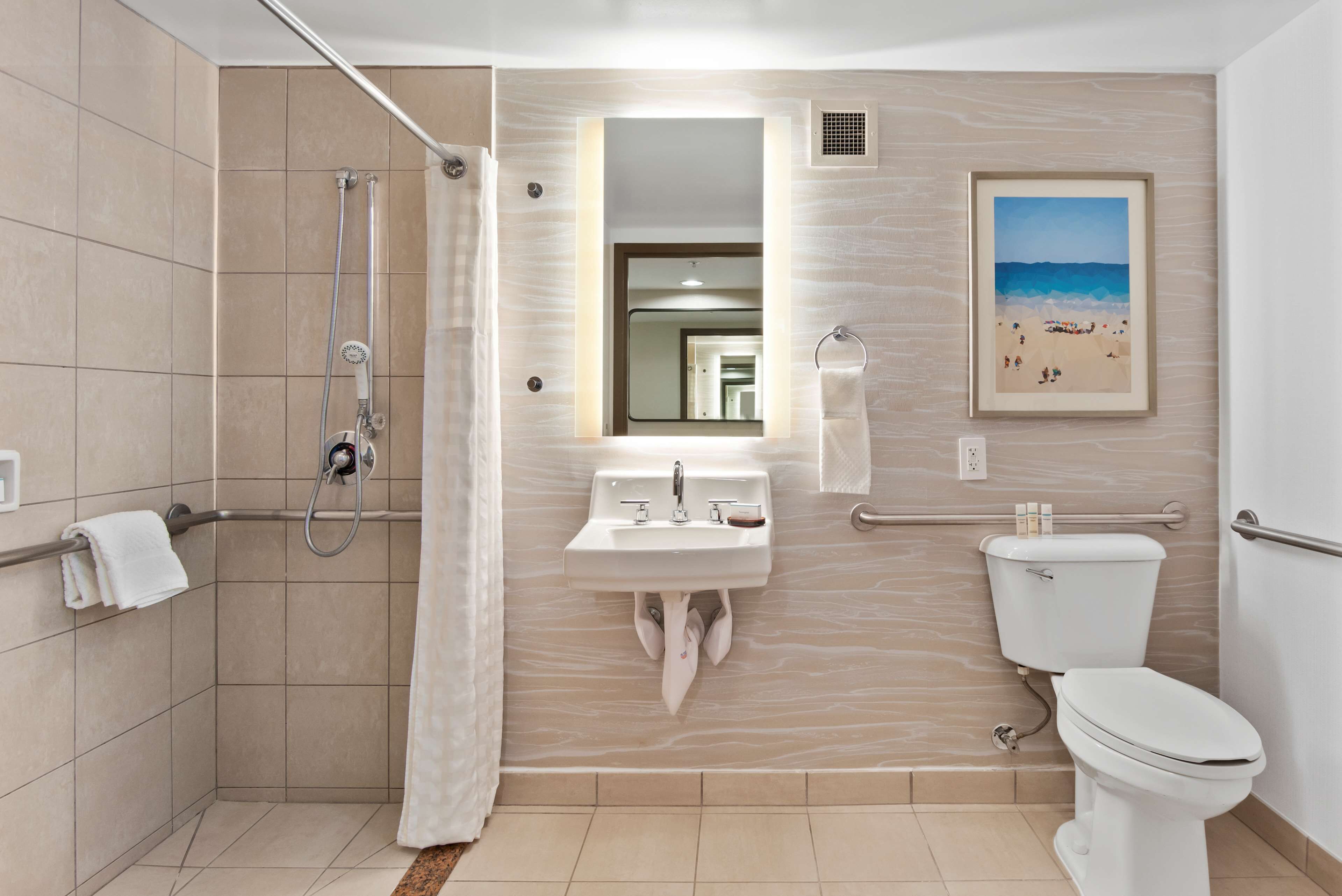A modern bathroom with a shower, sink, and toilet.