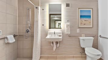 A modern bathroom with a shower, sink, and toilet.
