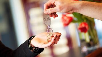 A hand holding a key with a metal plate that reads "3005".