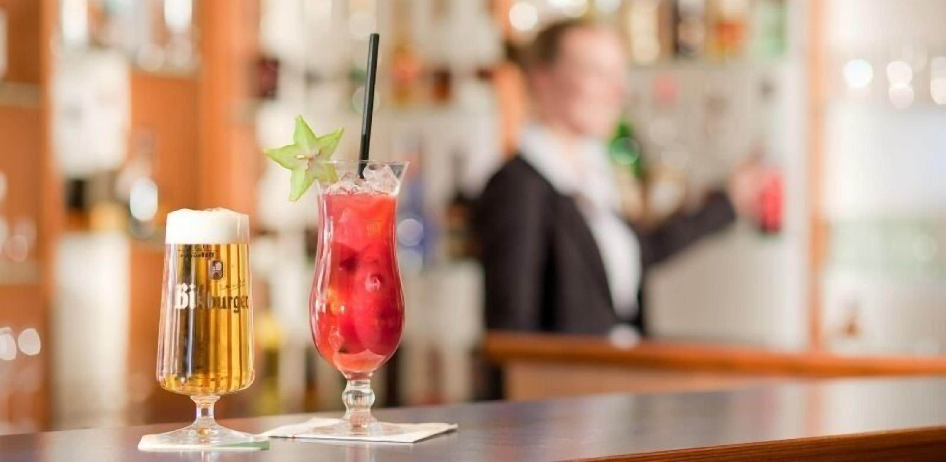Two drinks on a bar counter with a blurred background of a bar area.