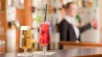Two drinks on a bar counter with a blurred background of a bar area.