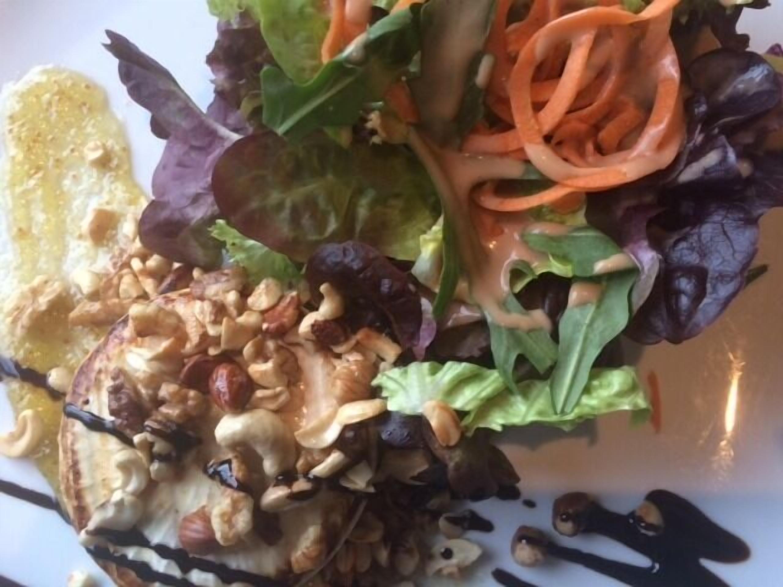 A plate of food with various vegetables and nuts.