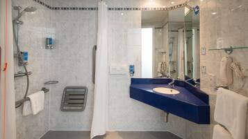 Un baño moderno con ducha, lavamanos y espejo.