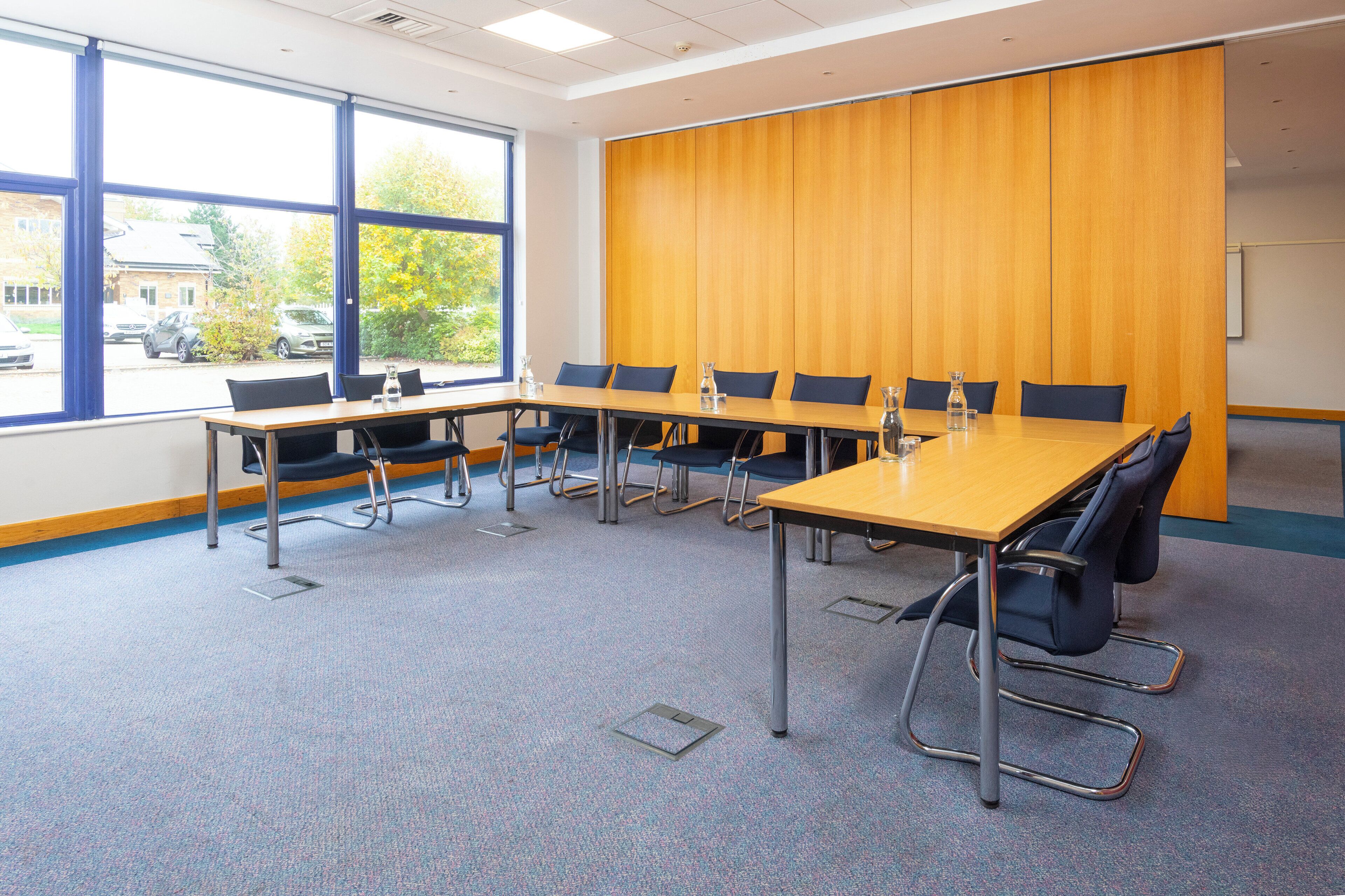 A conference room with a long table, chairs, and a large window.