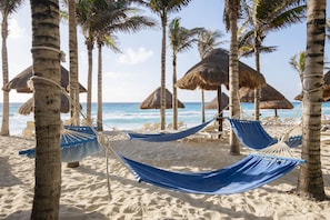 On the beach, white sand, beach cabanas, sun loungers