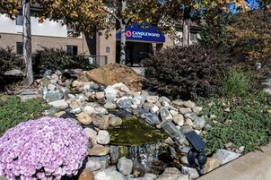 Un jardín con una cascada pequeña, rocas y un letrero de Candlewood Suites.