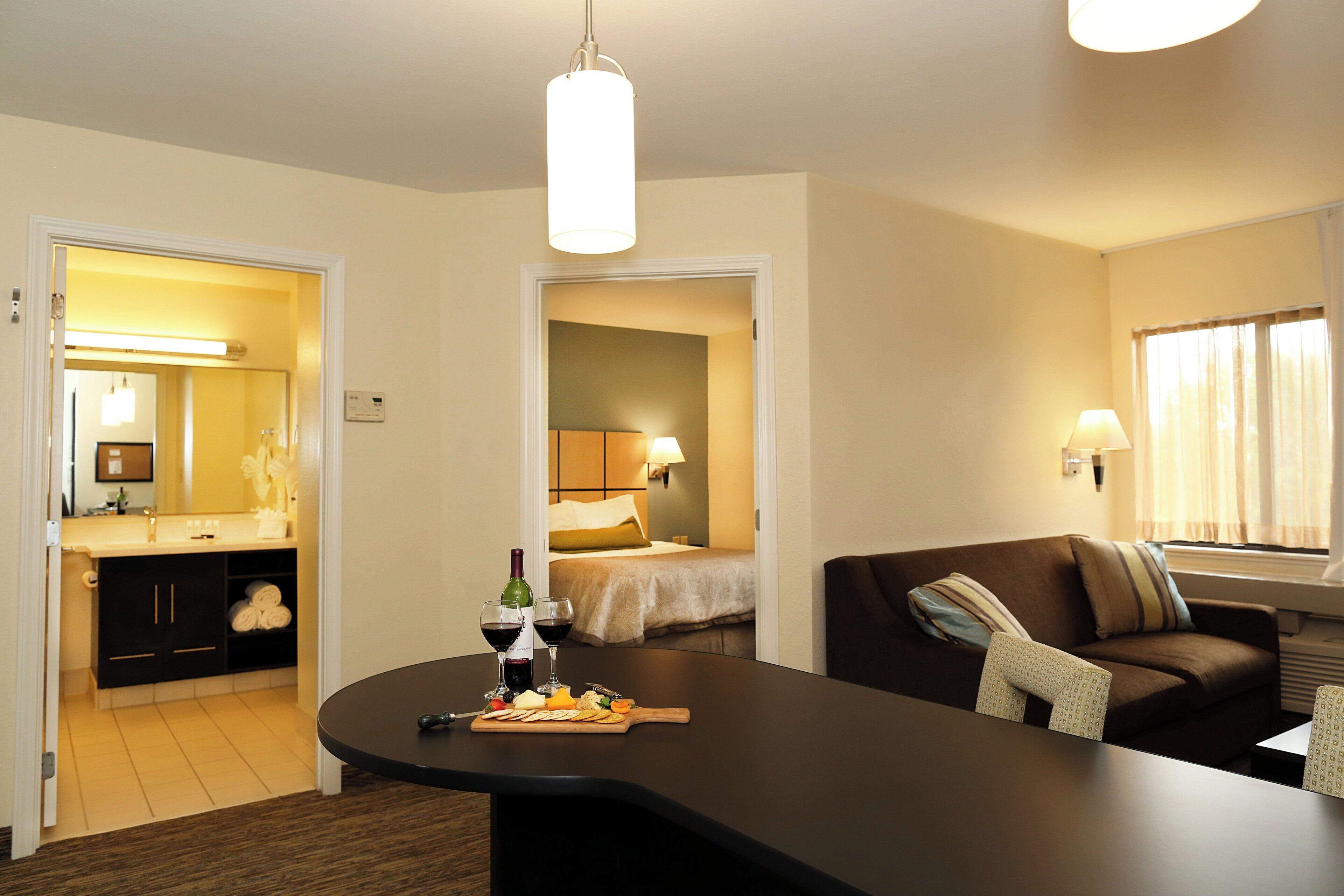 Una habitación de hotel con comedor, cama y sofá.
