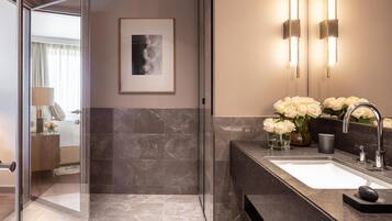 A modern bathroom with a large mirror, a sink, and a shower area.