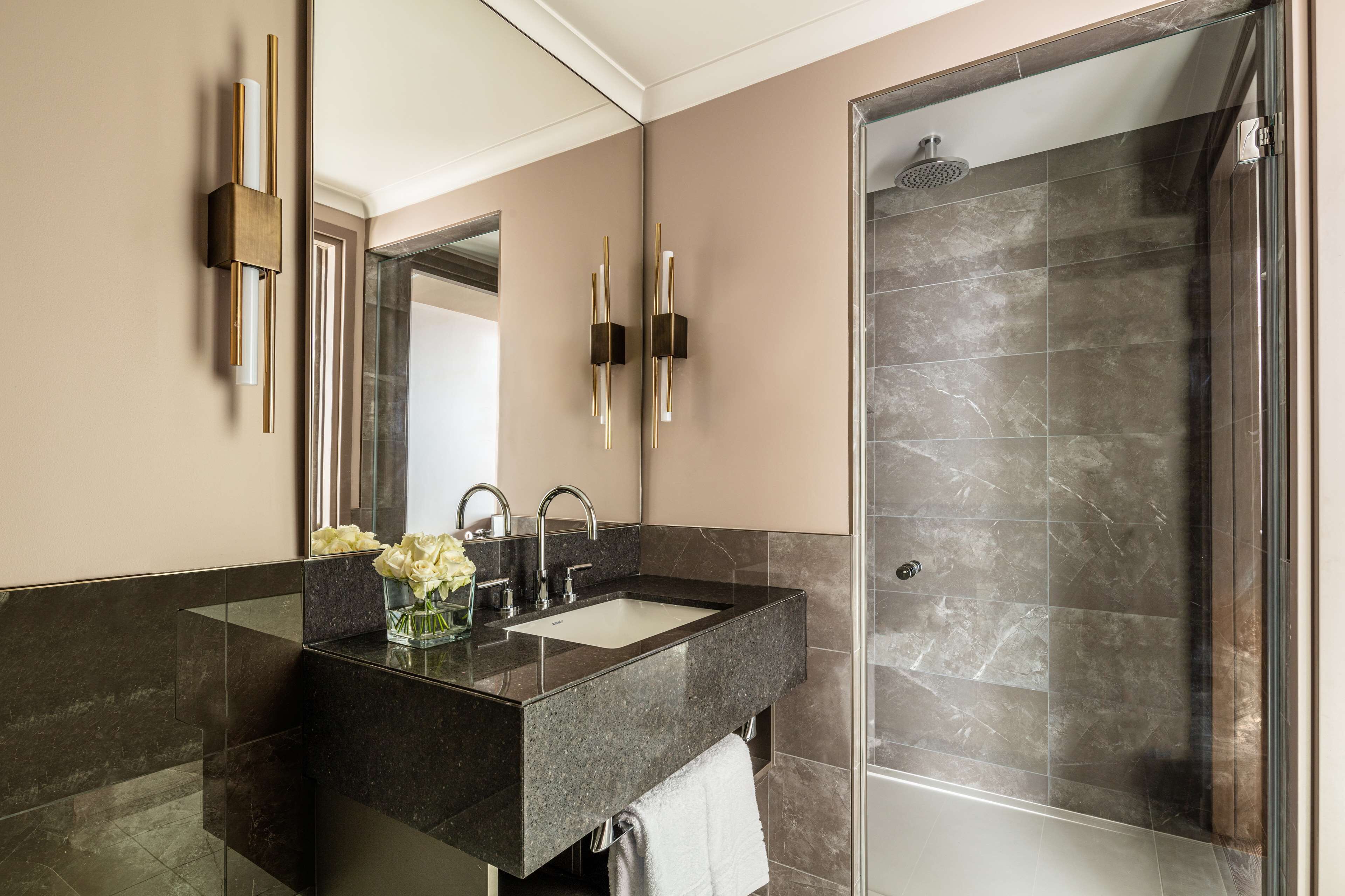 Une salle de bain moderne avec un meuble-lavabo en verre, une douche et un grand miroir.