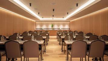 A conference room with a long table, chairs, and a central plant.