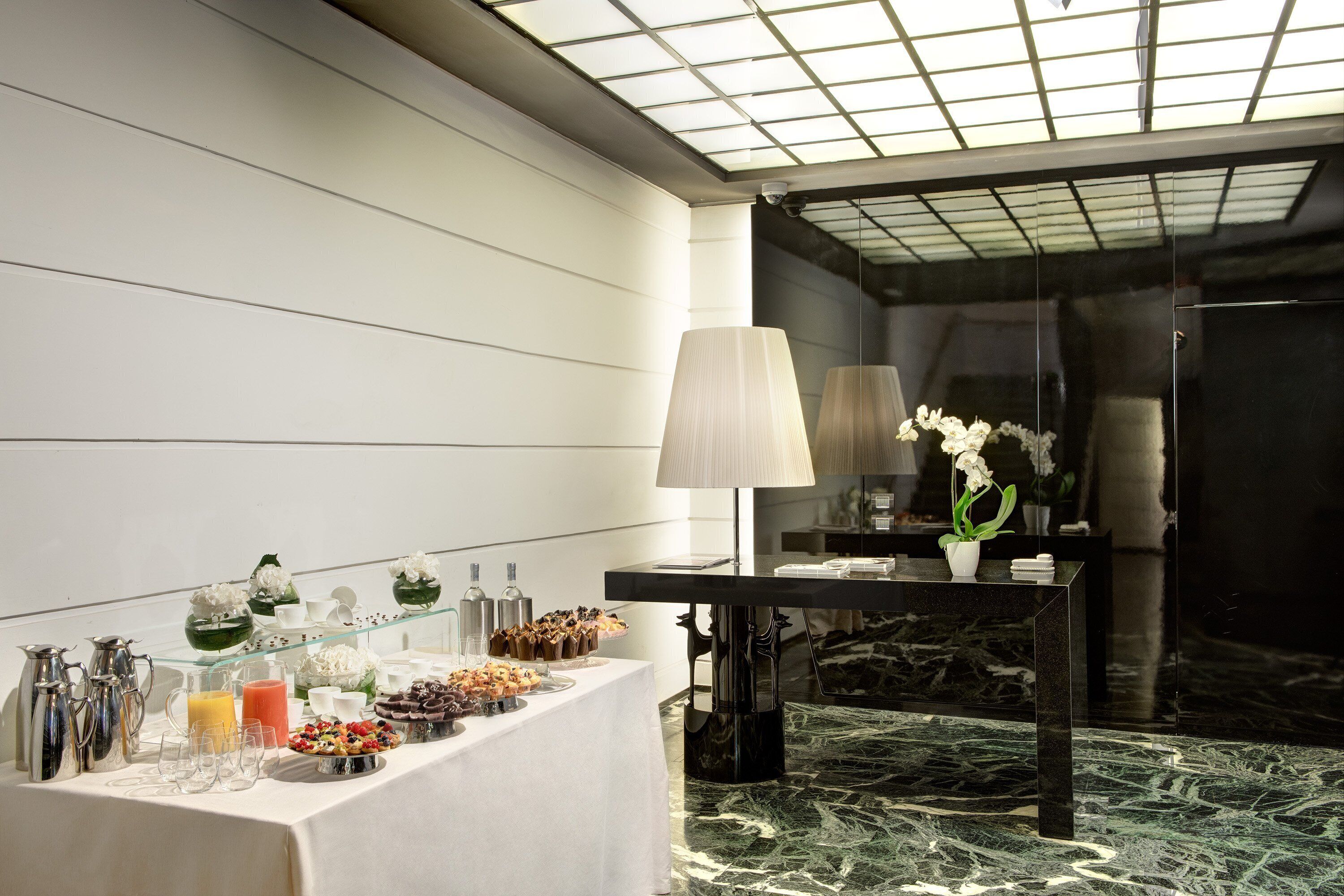 Un ricco buffet per la colazione con cibi e bevande assortite, un pavimento in marmo e un design d'interni moderno.