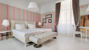 Una habitación de hotel con una cama grande, dos mesitas de noche, un escritorio y una silla.