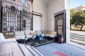 A modern hotel lobby with a seating area, a reception desk, and a decorative metal gate. - Grand Hotel Palace Rome (Rome)