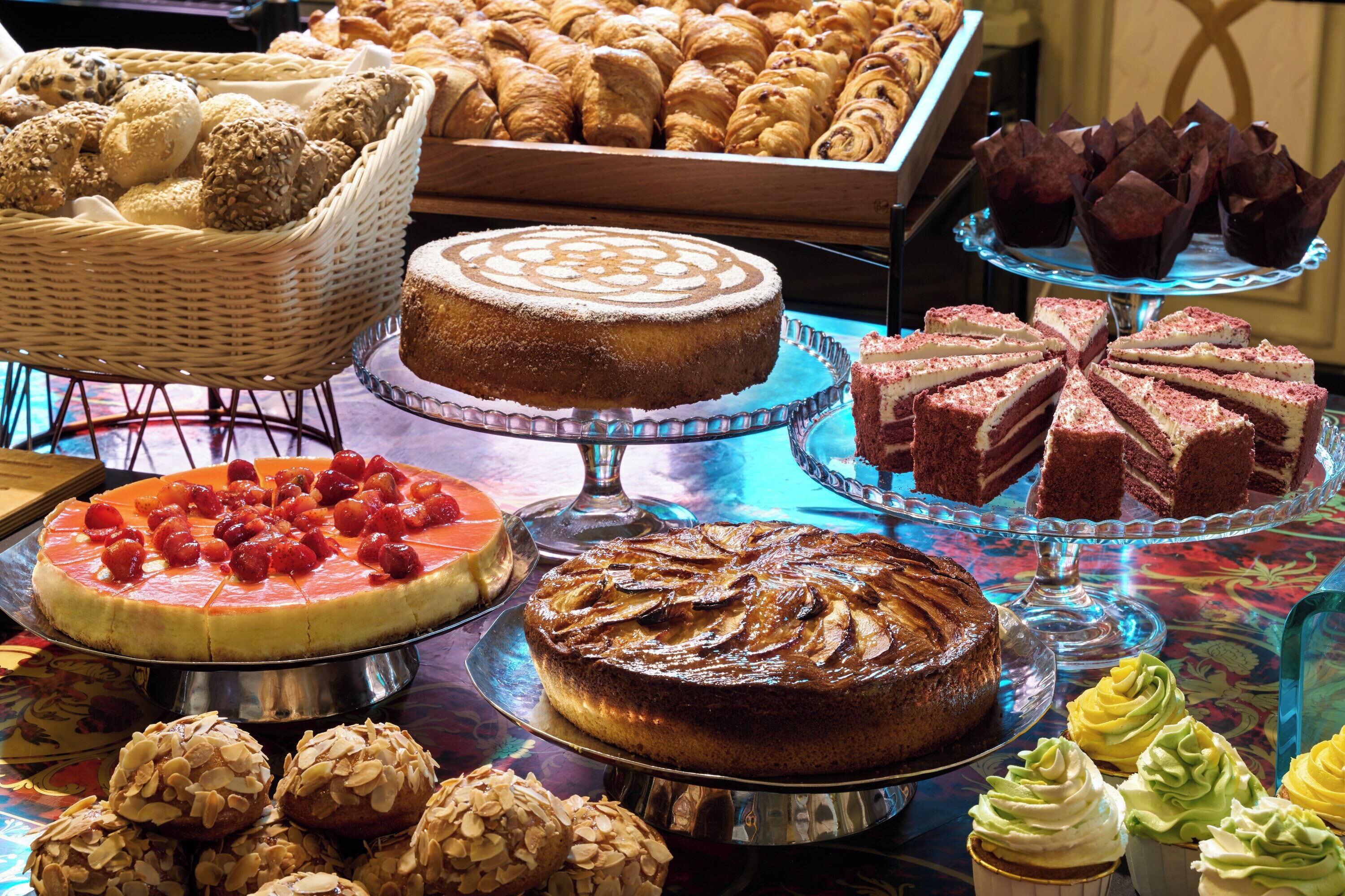 A variety of desserts on display, including cakes, pastries, and cupcakes.