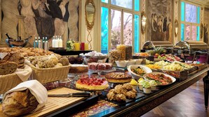 A buffet with various food items and a large painting on the wall. - Grand Hotel Palace Rome (Rome)