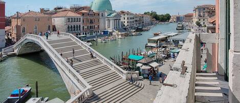 A bridge over a canal with historic buildings and a large dome in the background.