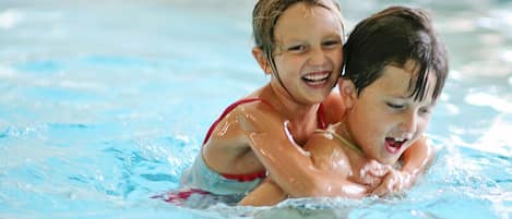 Two children swimming in a pool.