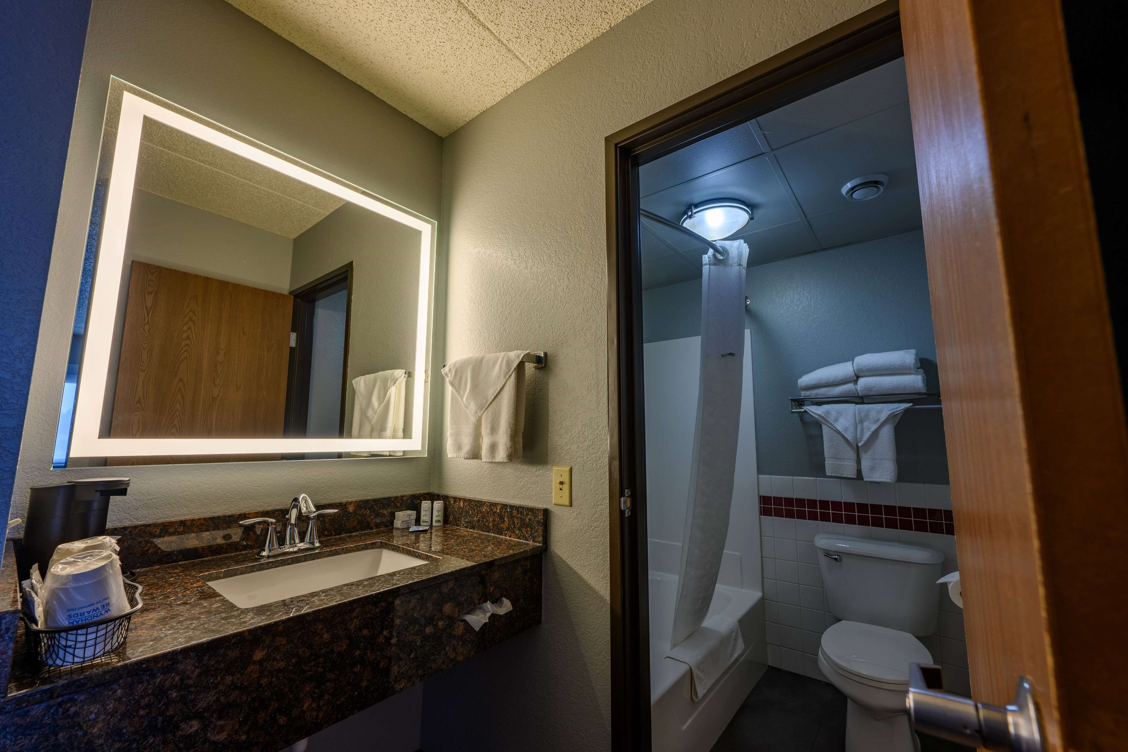 A bathroom with a sink, mirror, and toilet.