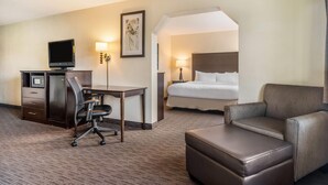 A hotel room with a desk, chair, television, and a bed. - Baymont by Wyndham Bloomington MSP Airport (Richfield)