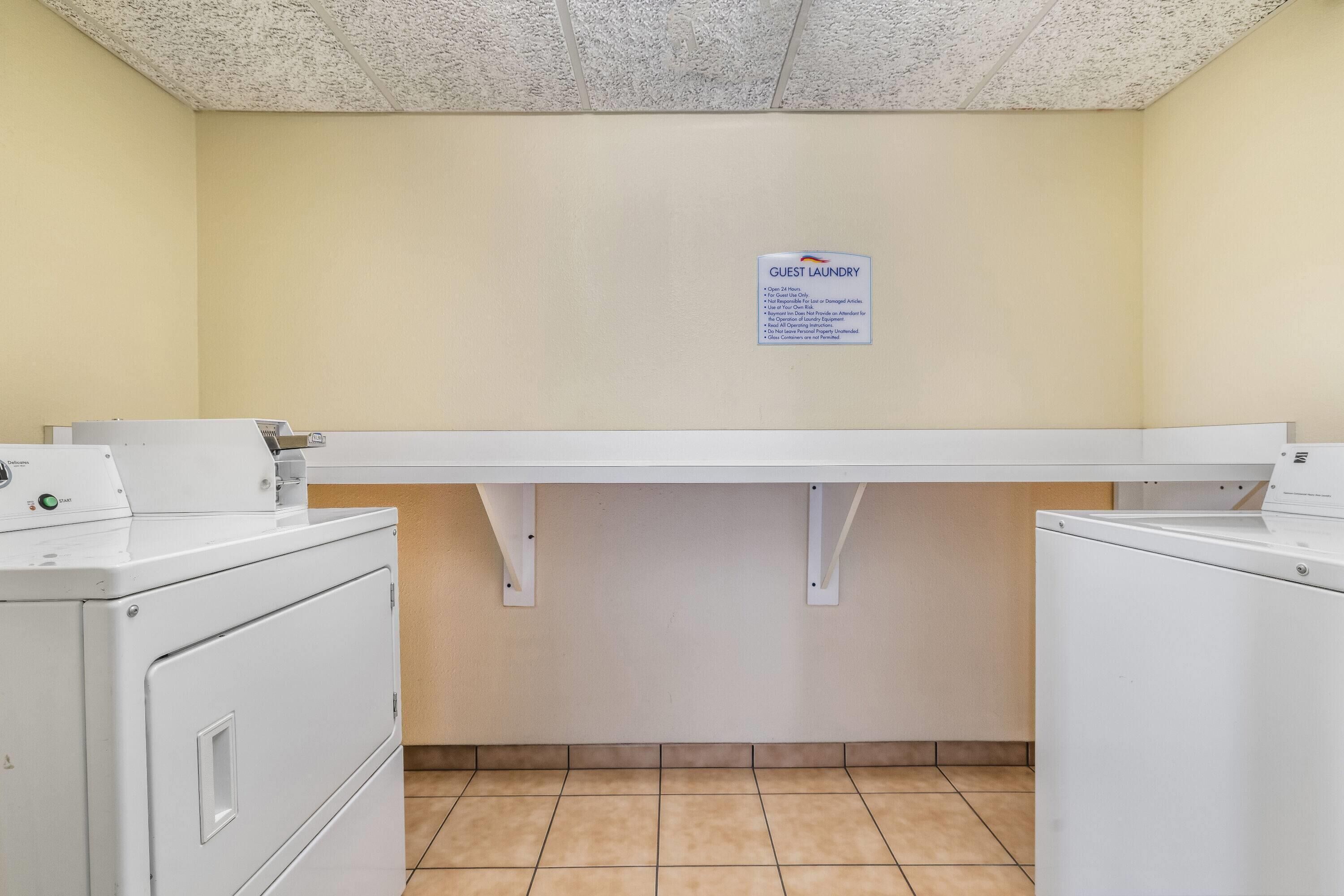 A laundry area with a sign indicating guest laundry services, including operating hours and usage guidelines.
