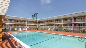 A motel with a swimming pool, multiple balconies, and outdoor seating. - Quality Inn Central Roseburg (Roseburg)