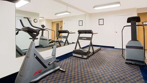 A gym with cardio equipment including treadmills and an elliptical, a mirror, and a steam generator.