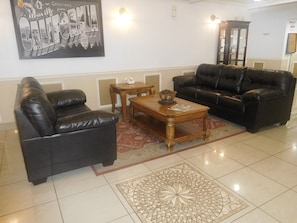 Relax in this inviting space with a cozy leather sofa, decorative coffee table, and elegant rug.