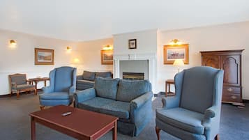 Relax in a cozy living room with a comfortable sofa, armchair, and fireplace.