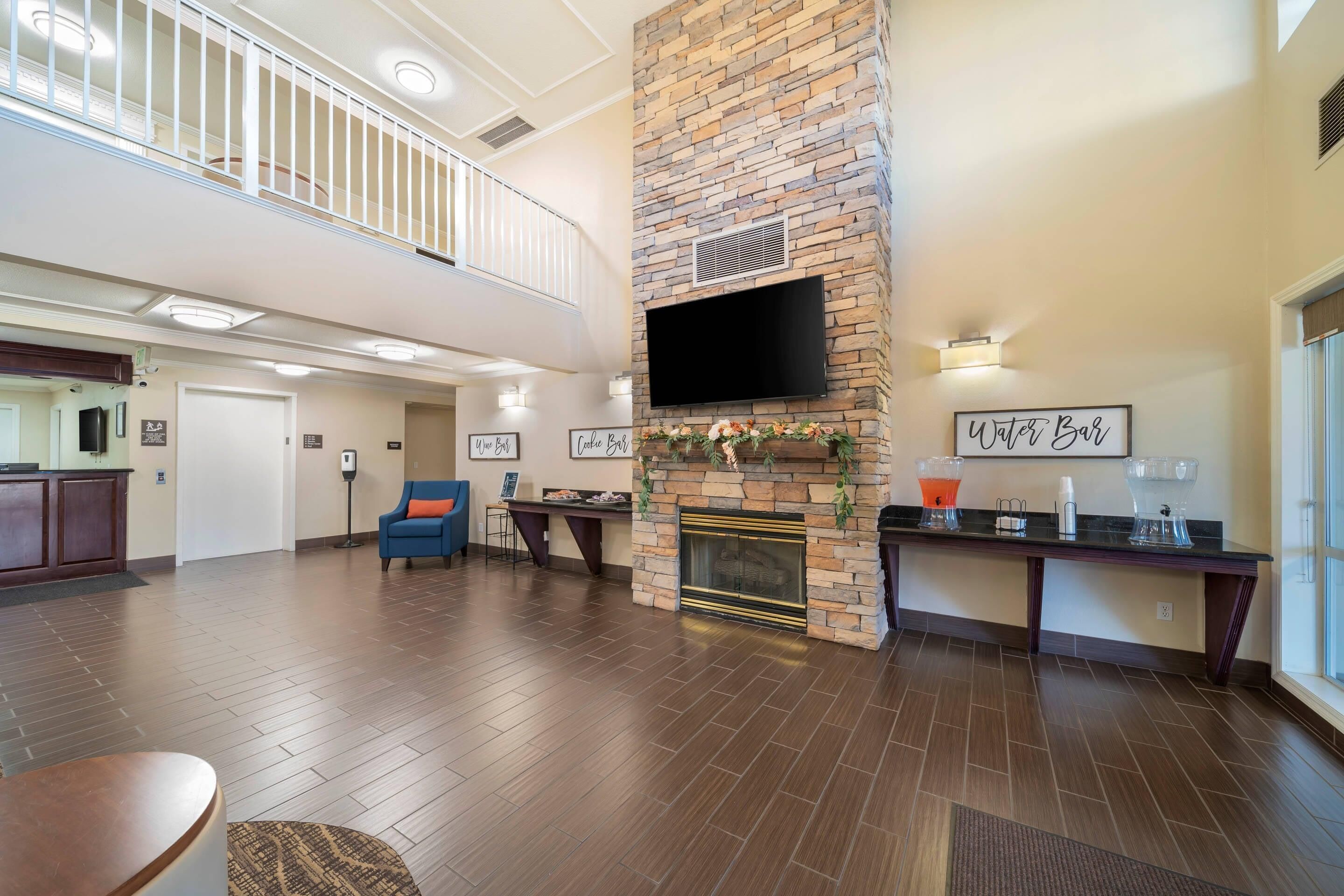 A spacious lobby with a fireplace, a flat-screen TV, and a water bar.