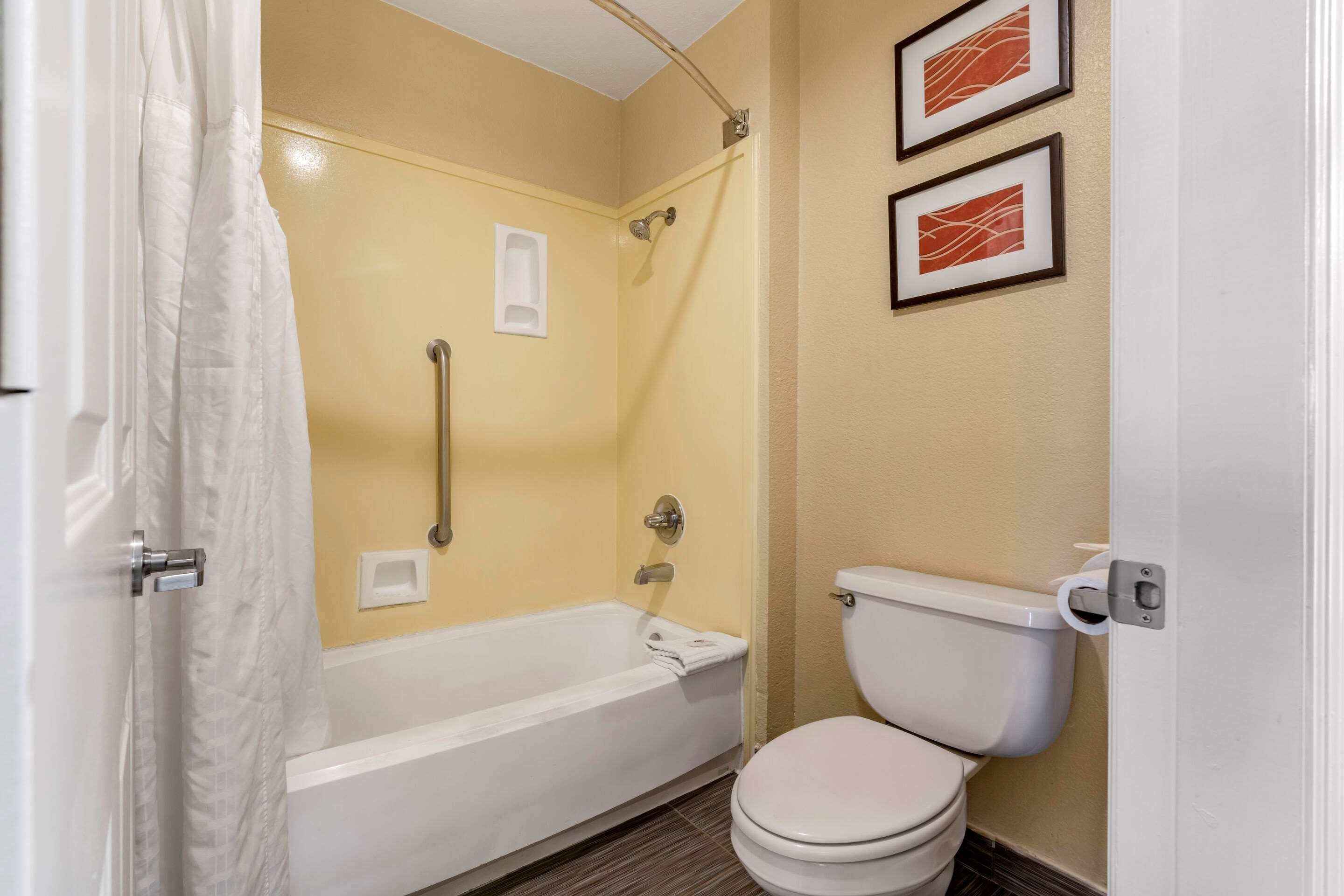 Une salle de bain avec une baignoire, des toilettes et une douche.