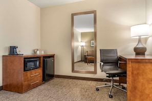 A hotel room with a kitchenette, a large mirror, a desk with a lamp, and a chair. - Comfort Suites Red Bluff near I-5 (Red Bluff)