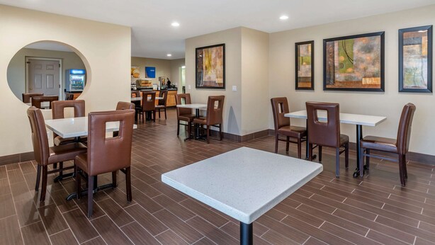 A dining area with tables and chairs, a vending machine, and artwork on the walls. - Comfort Suites Red Bluff near I-5 (Red Bluff)