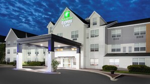 Un bâtiment de l’hôtel Holiday Inn Express & Suites, doté d’une entrée abritée et surplombant un ciel dégagé.