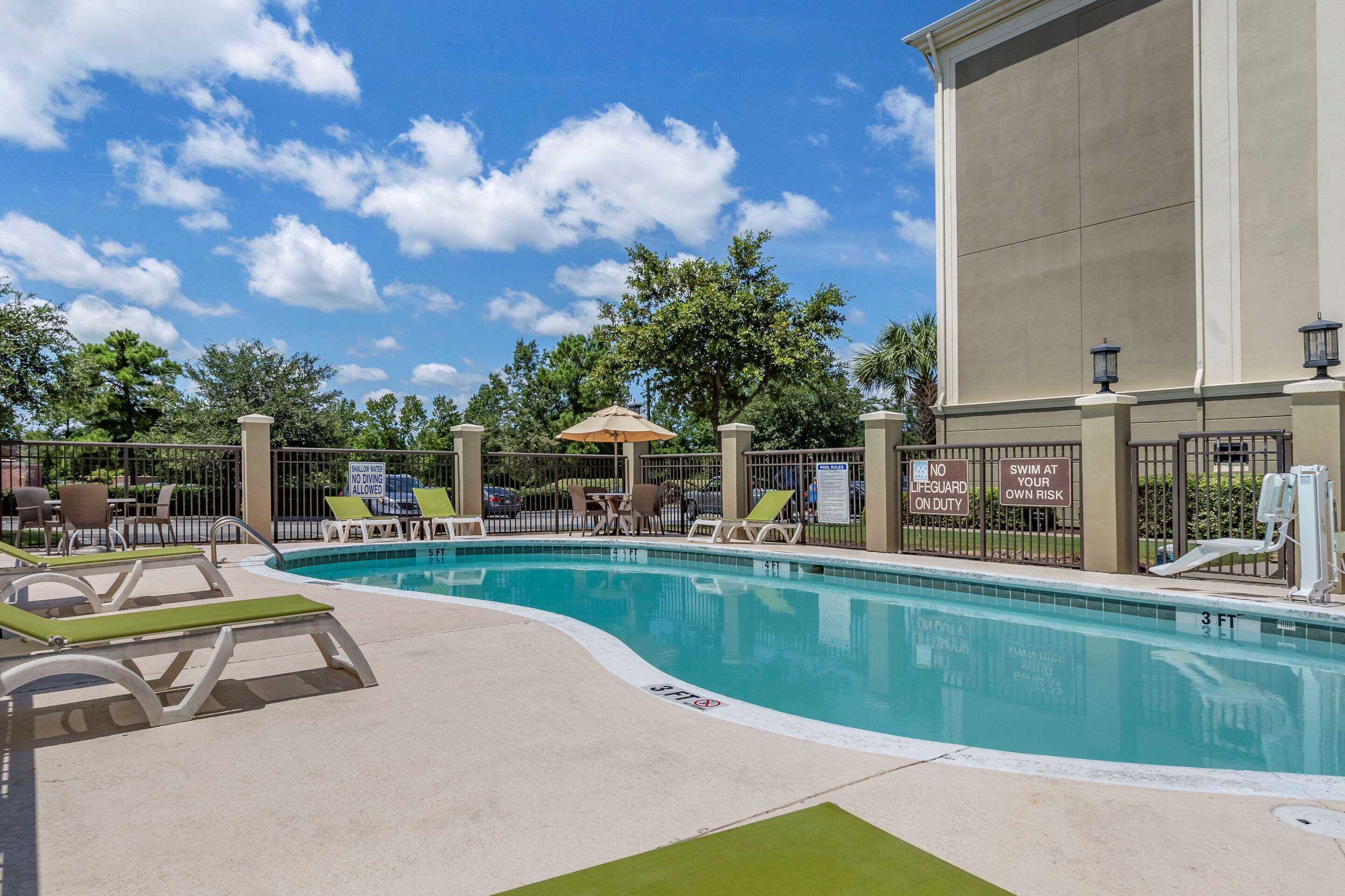 A swimming pool with lounge chairs and a lifeguard stand.