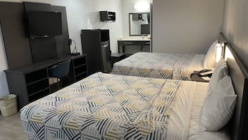 Une chambre d’hôtel avec deux lits, un bureau, une télévision et une salle de bain.