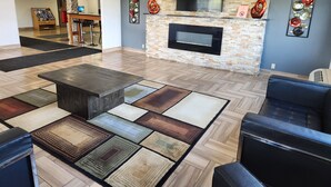 A spacious lobby with a fireplace, comfortable seating, and a variety of rugs.