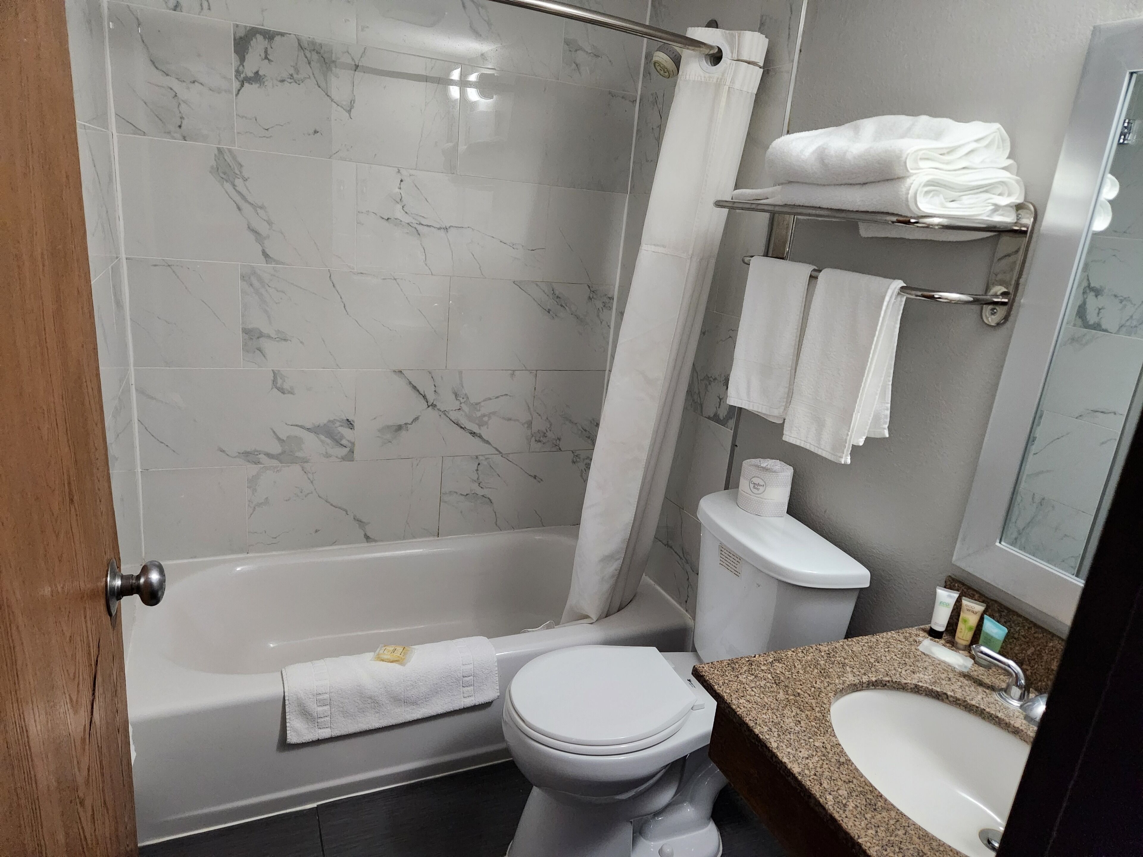 Un baño con bañera, inodoro y lavamanos.