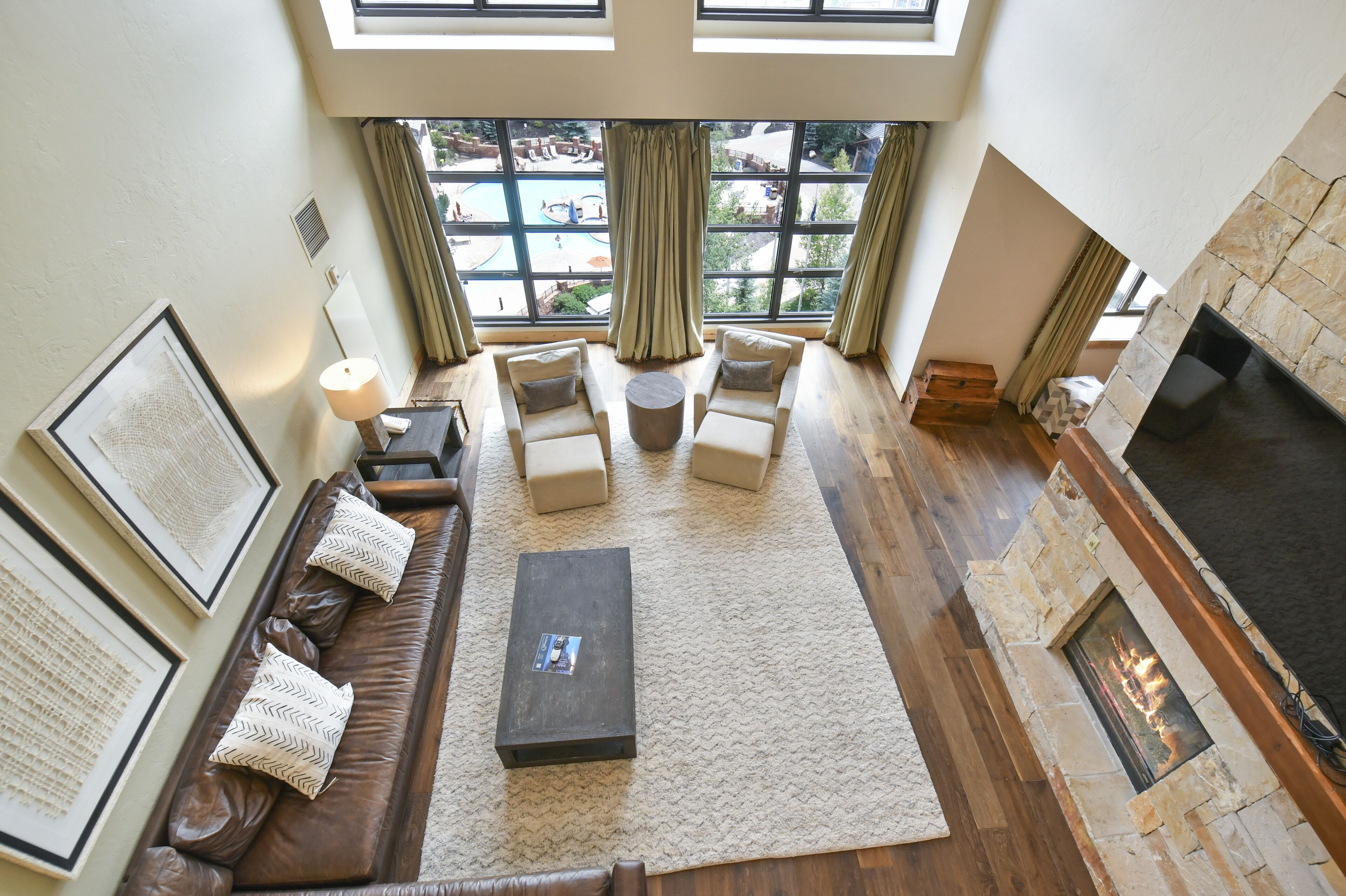 A spacious living room with a fireplace, large windows, and a cozy seating area.