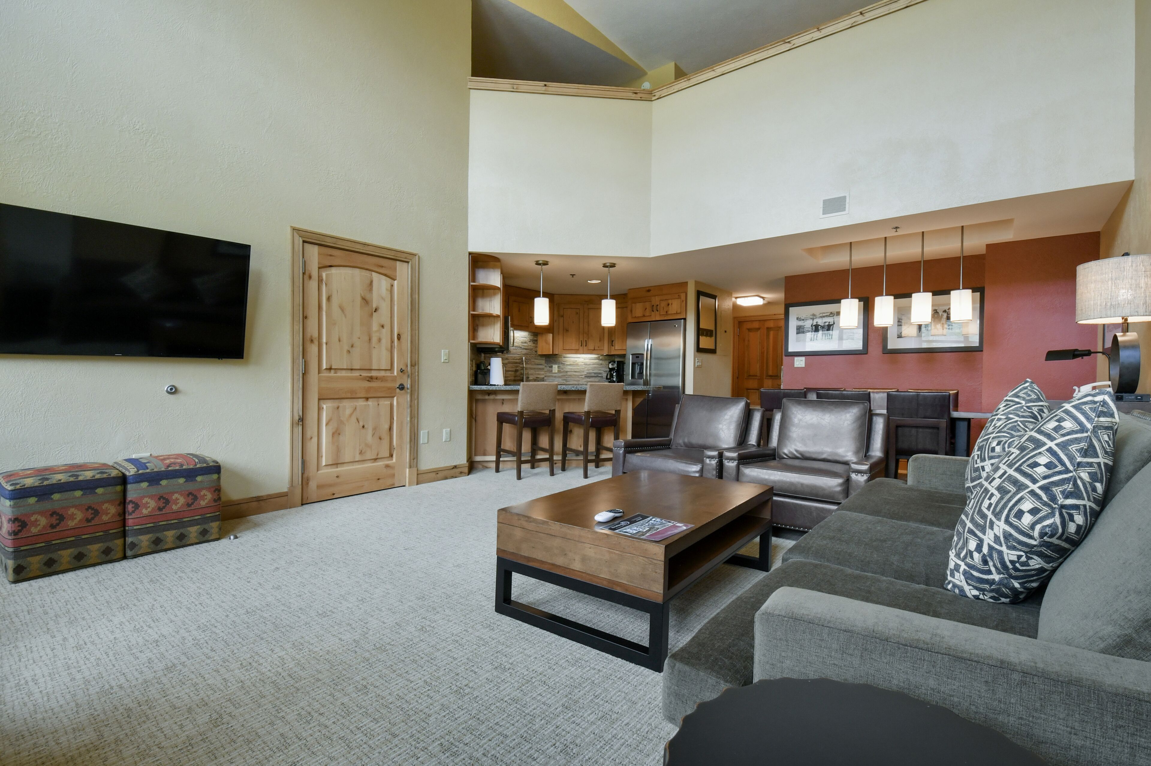 Amplia sala de estar con un televisor de pantalla plana grande, un sofá, una mesa de centro y una chimenea.