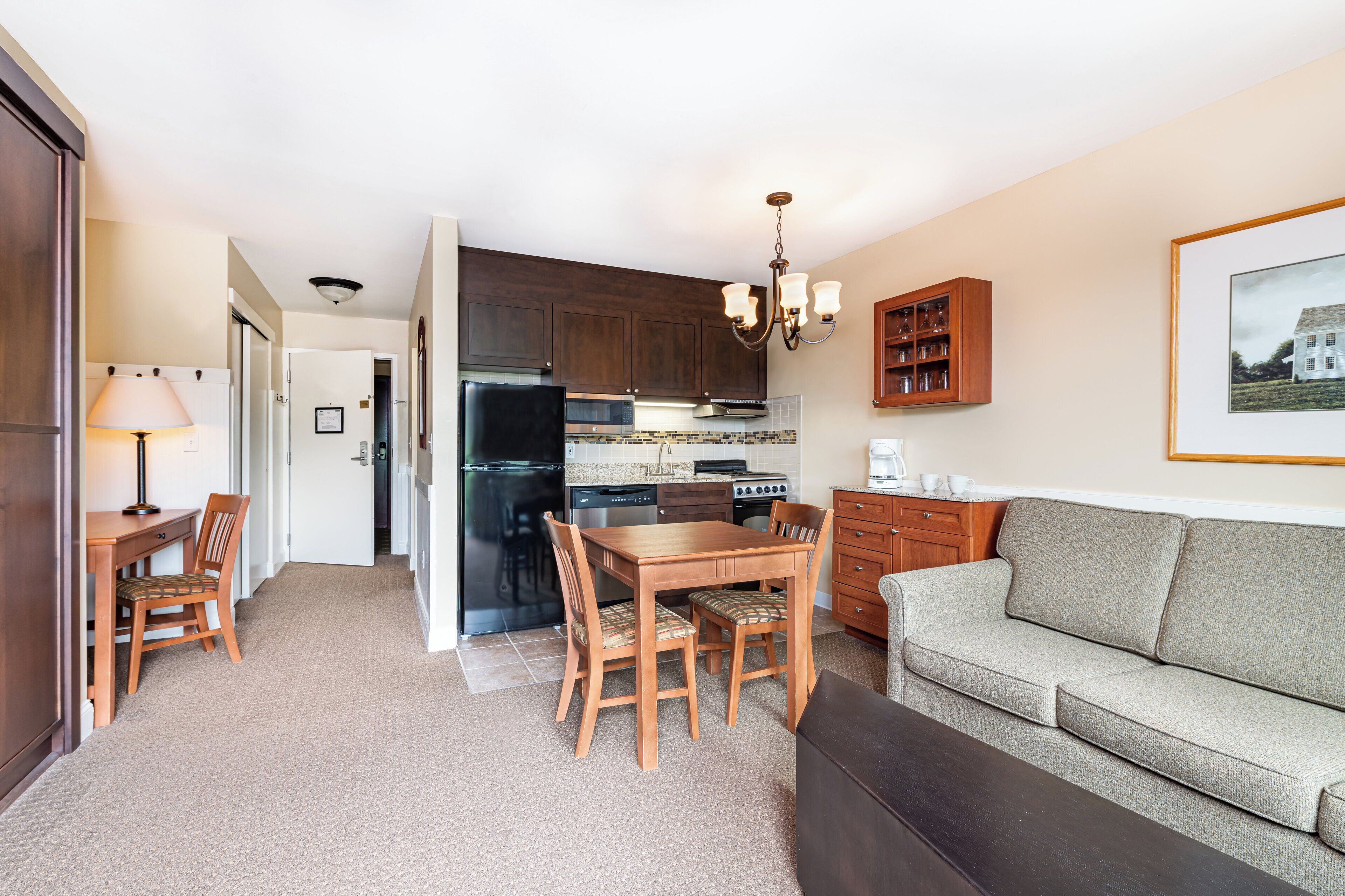 A compact living space with a dining area, kitchenette, and a sofa.