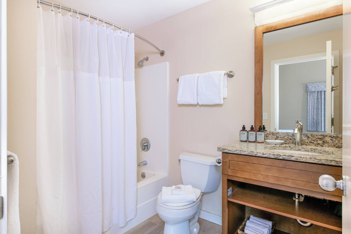 A bathroom with a bathtub, toilet, and sink.