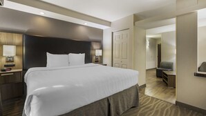 Una habitación de hotel moderna con una cama grande, mesitas de noche, un escritorio y una silla.