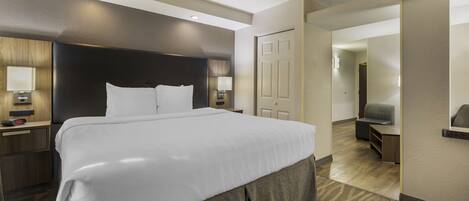 A modern hotel room with a large bed, bedside tables, a desk, and a chair.