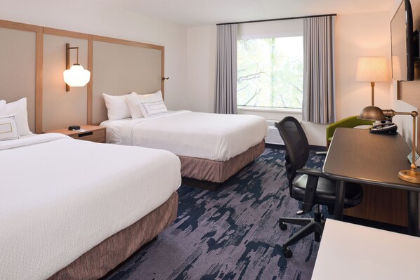 A hotel room with two beds, a desk, a chair, a lamp, and a large window with curtains. - Fairfield Inn by Marriott Pittsburgh New Stanton (New Stanton)