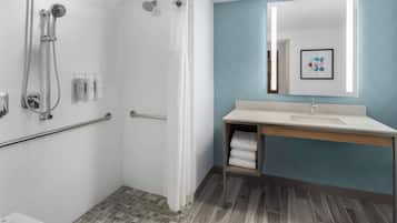 A modern bathroom with a shower, a sink, and a mirror.