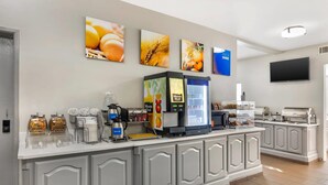 Un bar pour le petit-déjeuner équipé d’une machine à café, d’un distributeur de céréales et d’un four à micro-ondes.